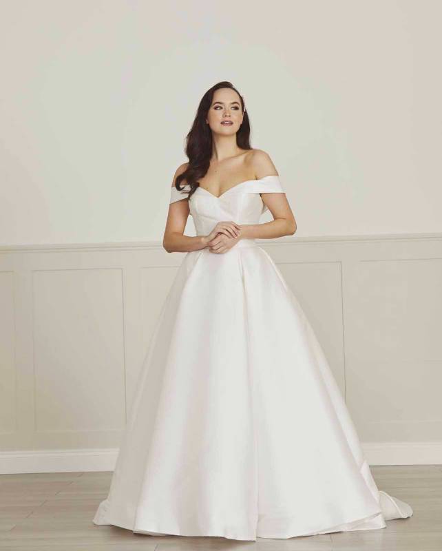 Full length view of white satin wedding dress with off shoulder straps